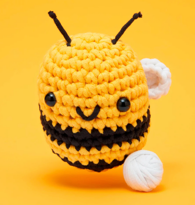 Woobles Crochet Kit Cornelius the Bee showing a yellow and black crocheted bee with white wings on a yellow background