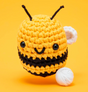 Woobles Crochet Kit Cornelius the Bee showing a yellow and black crocheted bee with white wings on a yellow background
