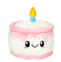 Happy Birthday Cake Snackers plush toy with smiling face, pink icing, sprinkles, and a yellow candle on top.
