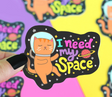 I Need My Space Cat Sticker featuring an astronaut cat floating in space with colorful text and stars.