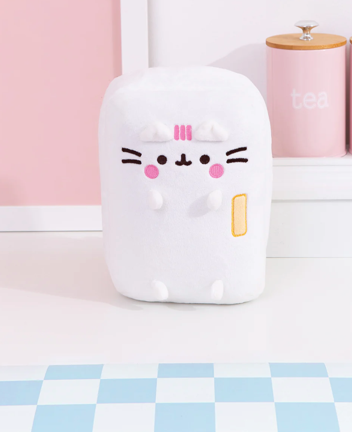 Pusheen Refrigerator plush in white with embroidered face and pink stripes, standing on a kitchen counter.