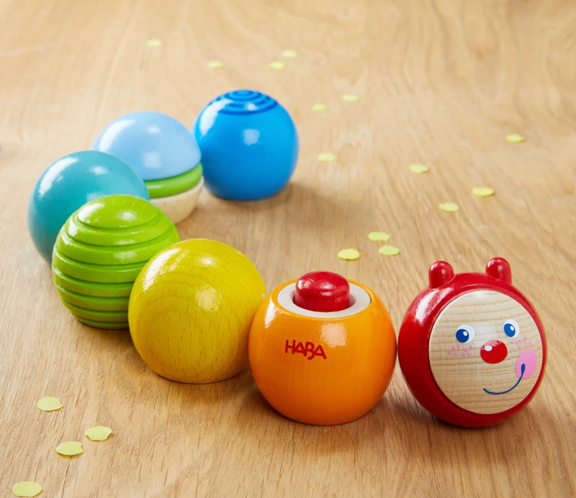 Discovery Building Blocks Caterpillar colorful wooden toy with smiling face and vibrant textured segments on wooden surface.