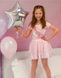 Girl wearing a pink sequin skirt holding a silver star balloon, smiling, Sequins Skirt | Party Fun Pink Neon.