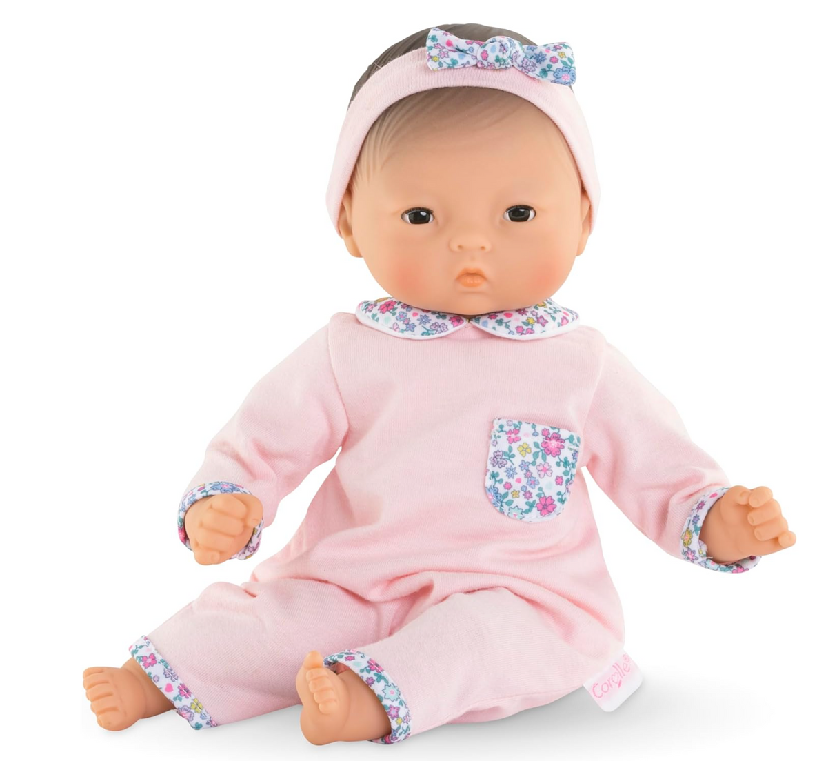 Calin Mila baby doll in pink floral outfit with headband, soft vinyl limbs, and cuddly poseable body.