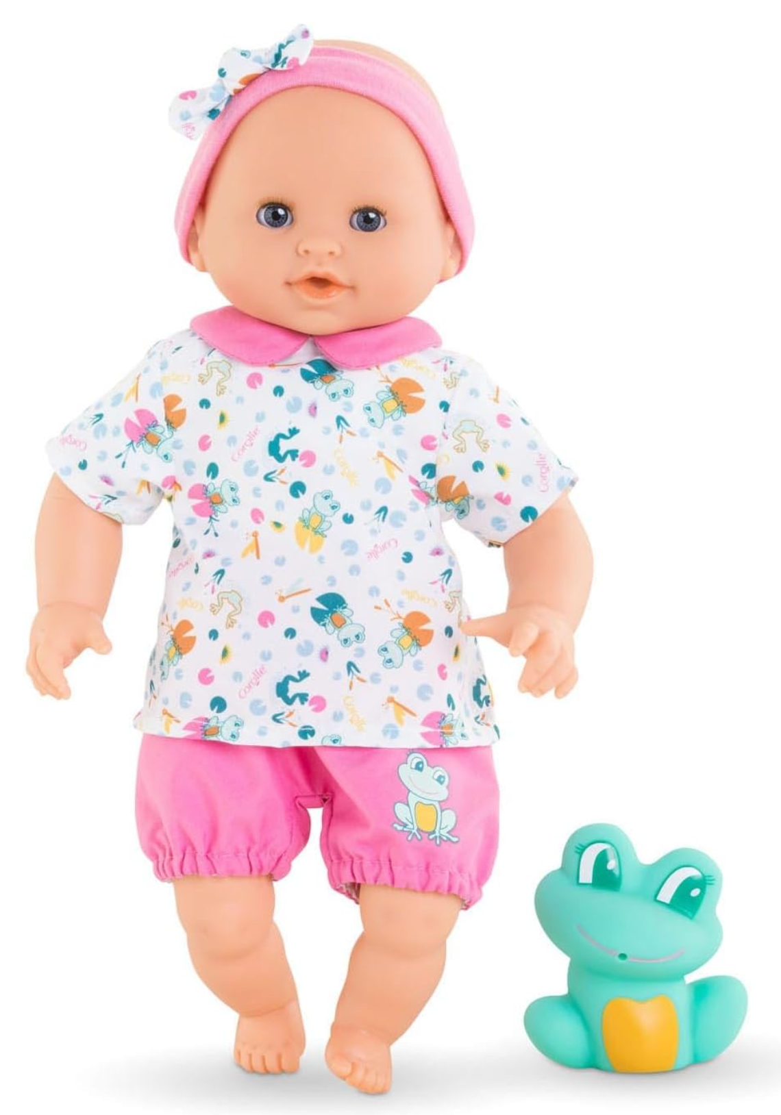 Bath Baby Oceane doll wearing colorful clothes with pink shorts and headband, standing next to a green frog toy.
