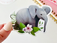 Elephant Sticker showing a cute baby elephant with flowers, perfect for laptops and notebooks, glossy vinyl, 2x3 inches.