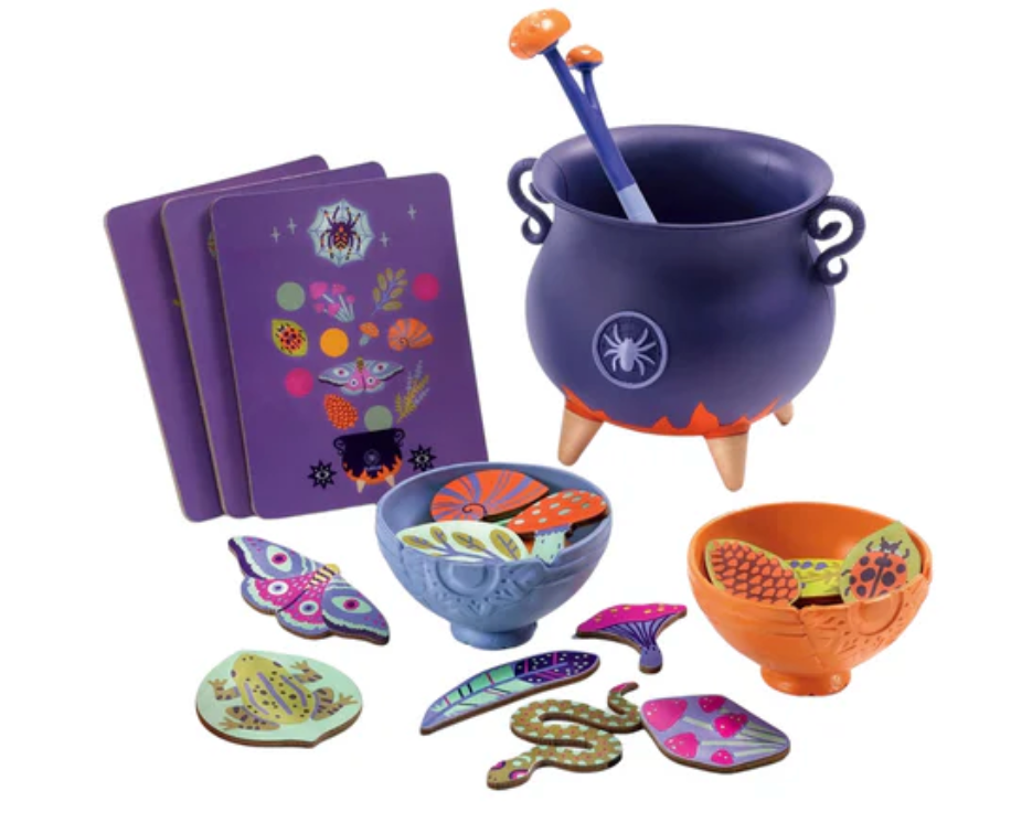Djeco Witch's Brew set with purple cauldron, ladle, colorful wooden ingredients, bowls, and illustrated menu cards for kids.