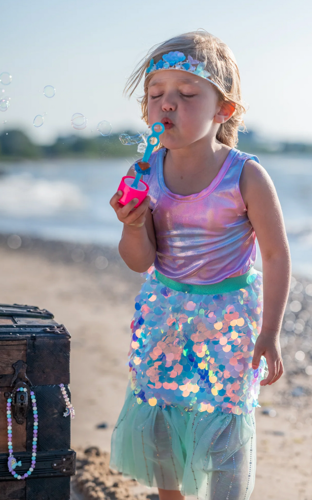 Bling Bling Mermaid Skirt & Hairclip | Mint worn by child blowing bubbles on beach with shimmering skirt and teal waistband.