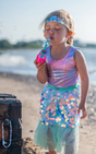 Bling Bling Mermaid Skirt & Hairclip | Mint worn by child blowing bubbles on beach with shimmering skirt and teal waistband.