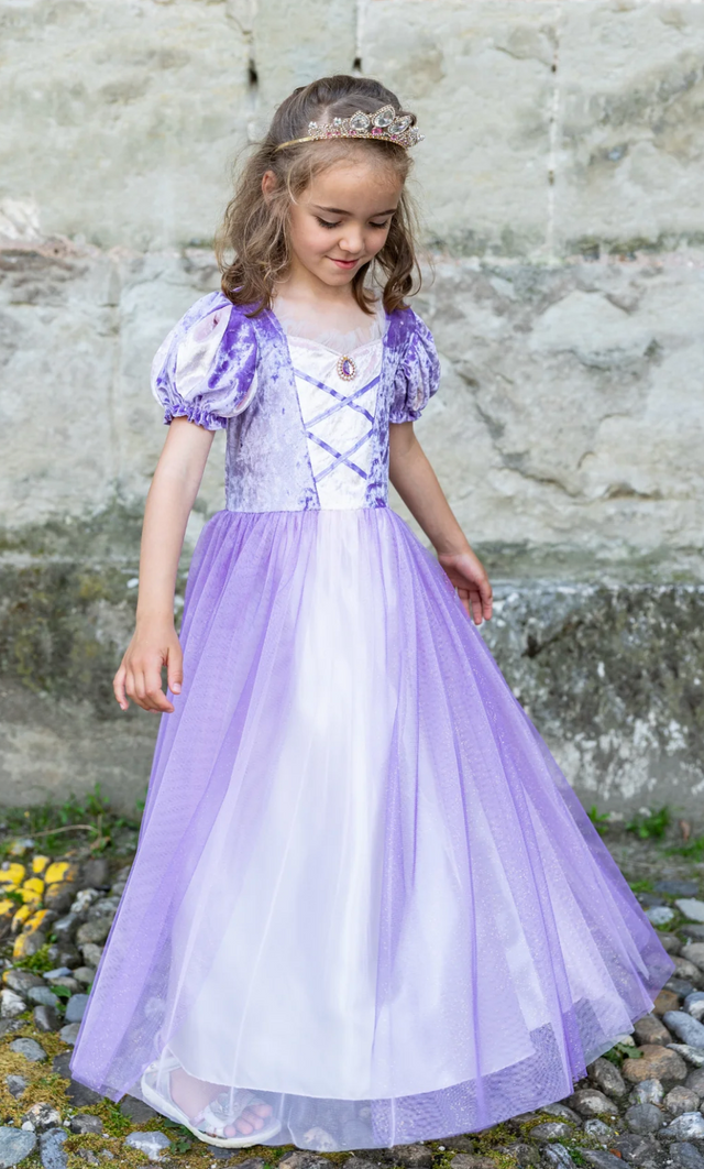 Little girl wearing the Once Upon a Tower Princess Dress in purple velvet with puffed sleeves and flowing tulle skirt.