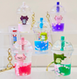 Axolotl Boba Floaty KeyChain featuring colorful axolotl figures inside boba drink charms with floating petals and straws.
