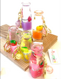 Fruit Bottle Floaty KeyChain with colorful fruit designs floating inside clear bottles on gold key rings.