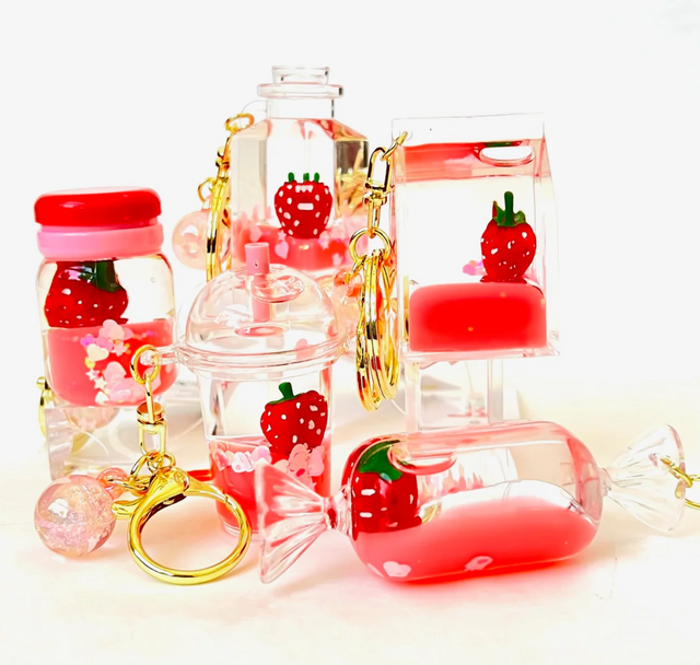 Strawberry Floaty KeyChain with playful floating strawberry design in assorted clear colorful shapes and gold key rings.