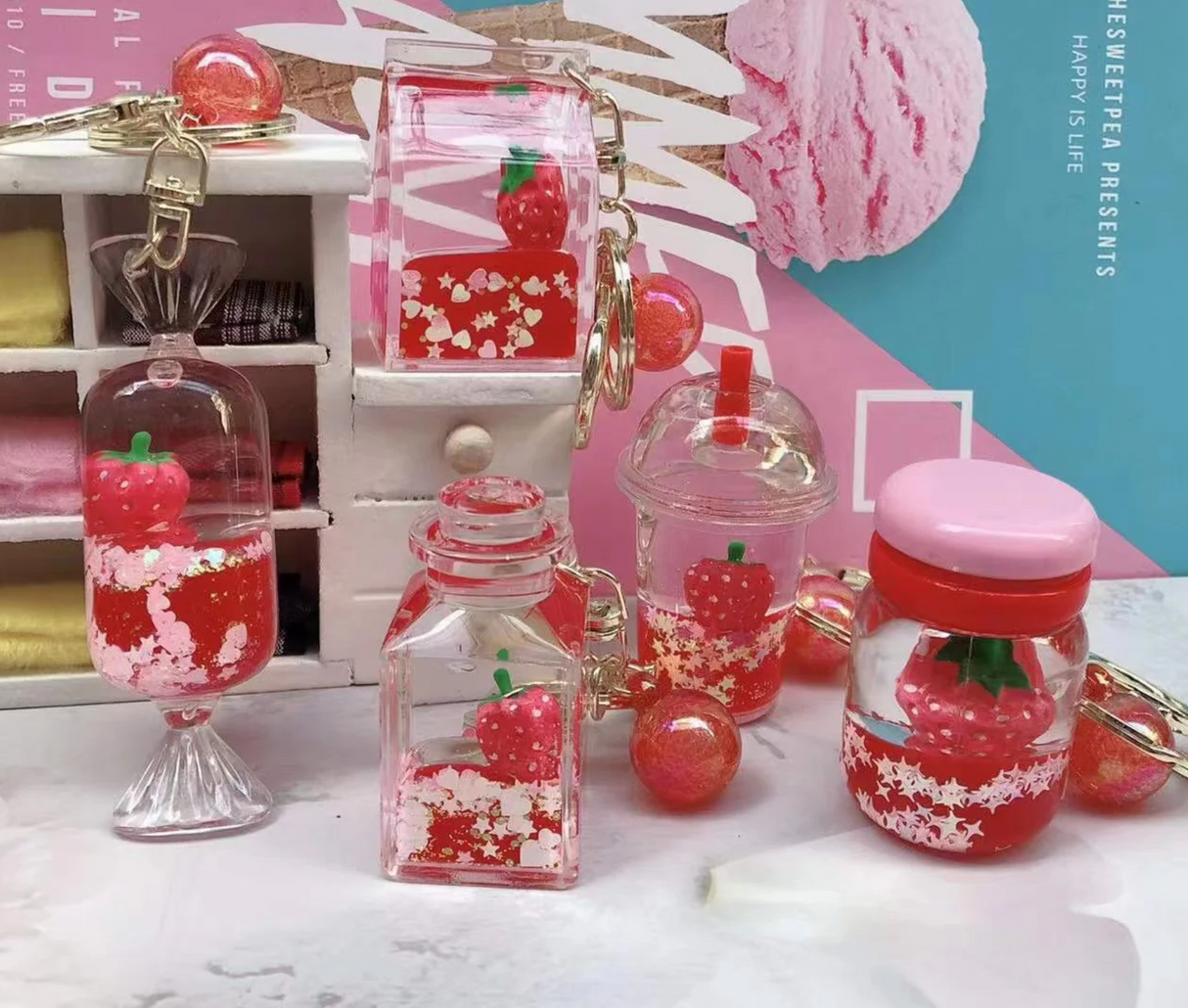 Strawberry Floaty KeyChain featuring playful strawberry designs in assorted shapes with floating glitter inside clear cases.