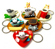 Colorful Cat Cafe KeyChain set featuring playful cats in coffee cups and saucers with cookies and cinnamon sticks.