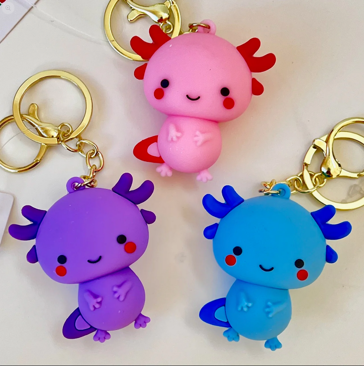 Axolotl Figurine KeyChain in assorted pink, purple, and blue colors with playful smiling faces.