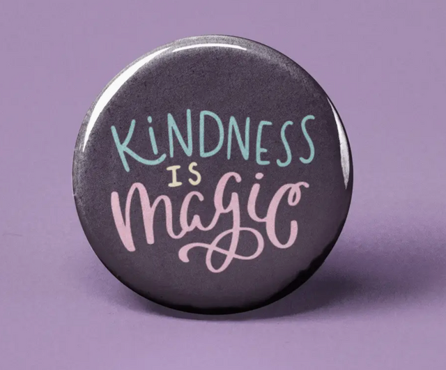 Button | Kindness is Magic with pastel text on a dark background, promoting positivity and kindness on a purple surface.