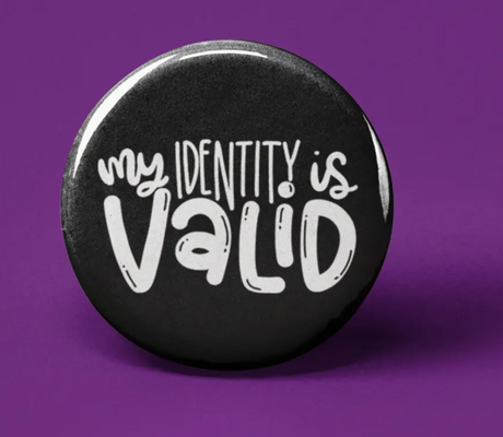Button | My Identity is Valid black circular pin with white handwritten text on a purple background