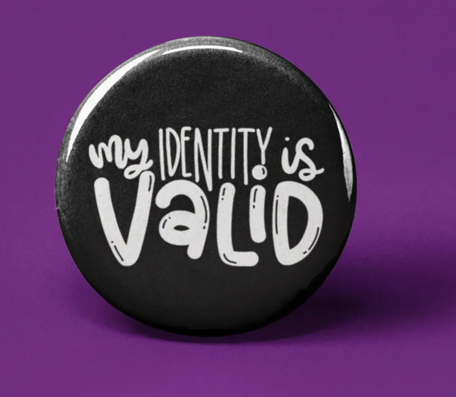 Button | My Identity is Valid black circular pin with white handwritten text on a purple background