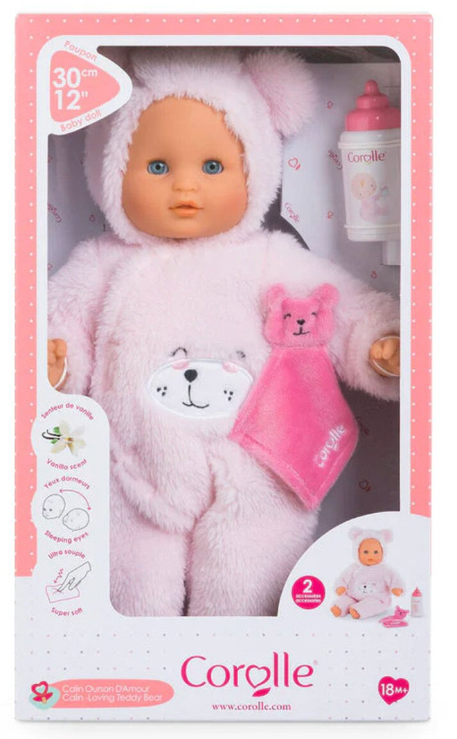 Calin Loving Teddy Bear doll in pink suit with blue eyes, holding a lovey and feeding bottle in packaging.