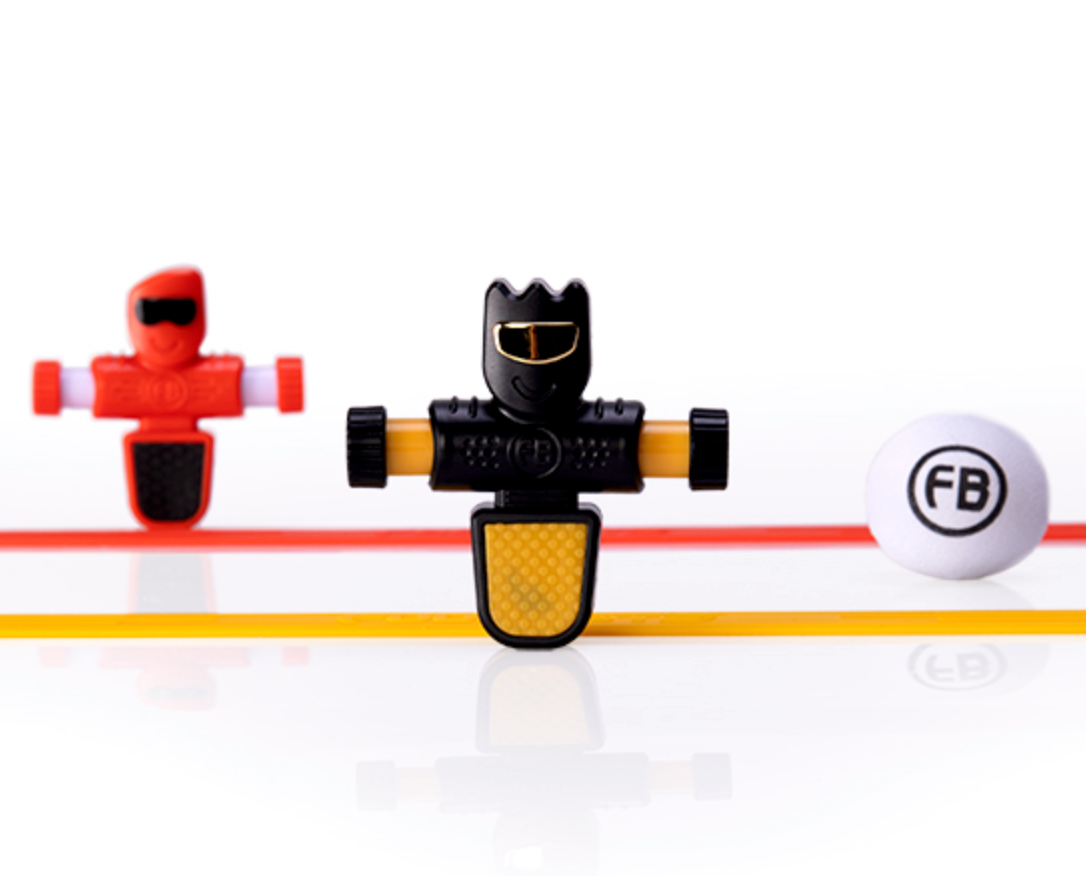 Foosbots 2 Pack featuring two colorful Foosbot players, silicone goal lines, and a ball for fast-paced tabletop gameplay.