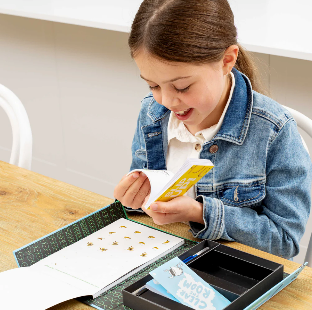 Young girl enjoying creating animations with the Flip Book Kit | Animation in Action at a wooden table.