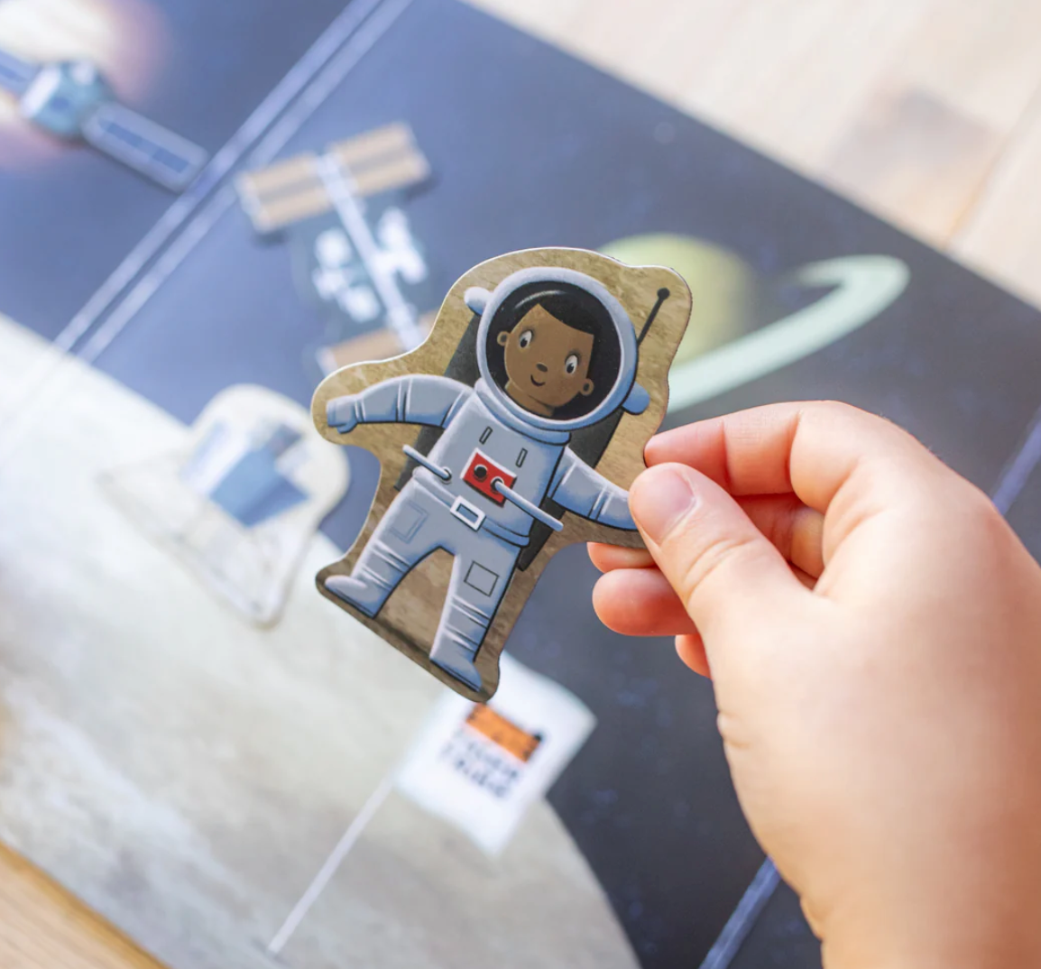 Child holding astronaut magnet piece from Magna Carry | Space Explorer fold-out magnetic playset.