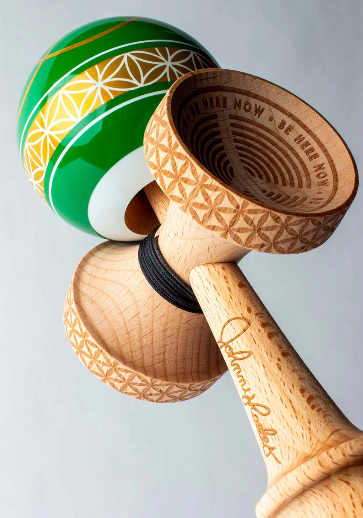Close-up of the Kendama Johnny Raekes V2 BS Sticky with detailed wood design and green, yellow patterned tama.