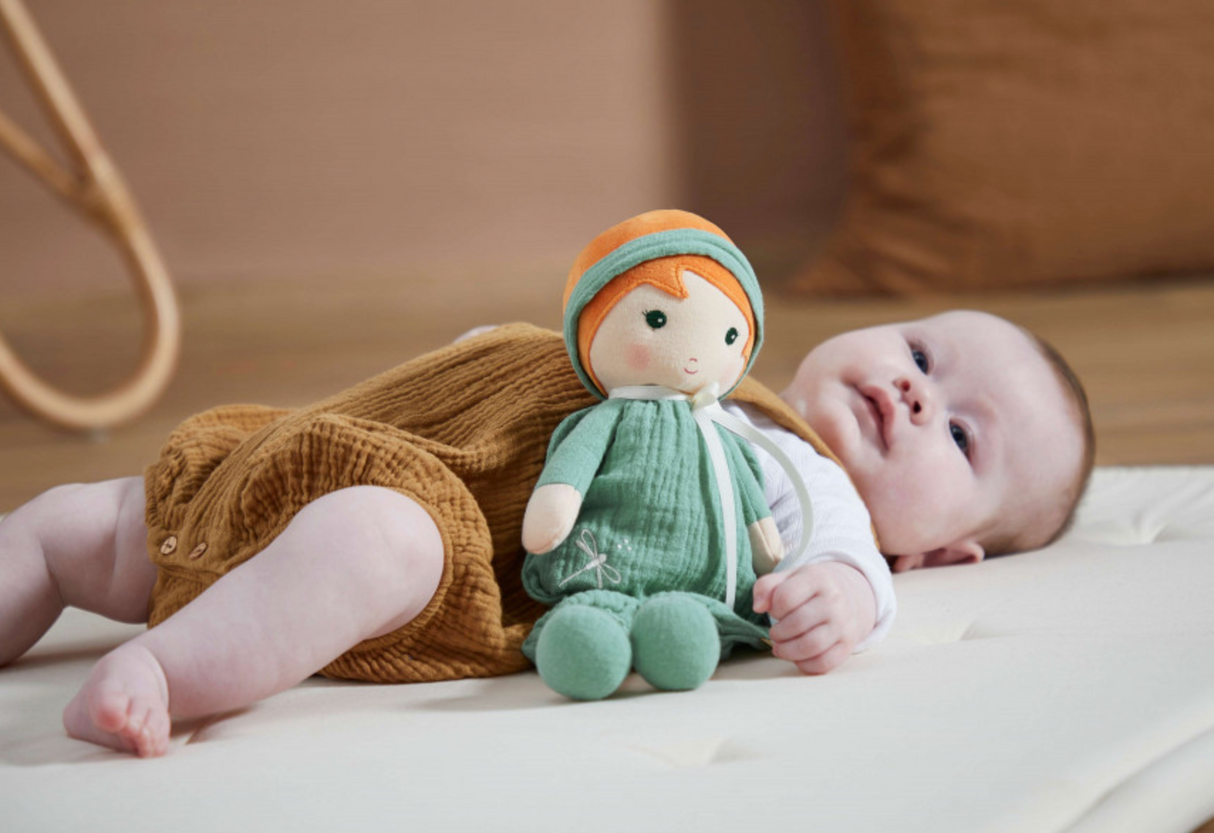 Tendresse | Olivia fabric doll in olive dungarees with headband, next to a baby lying on a mattress.