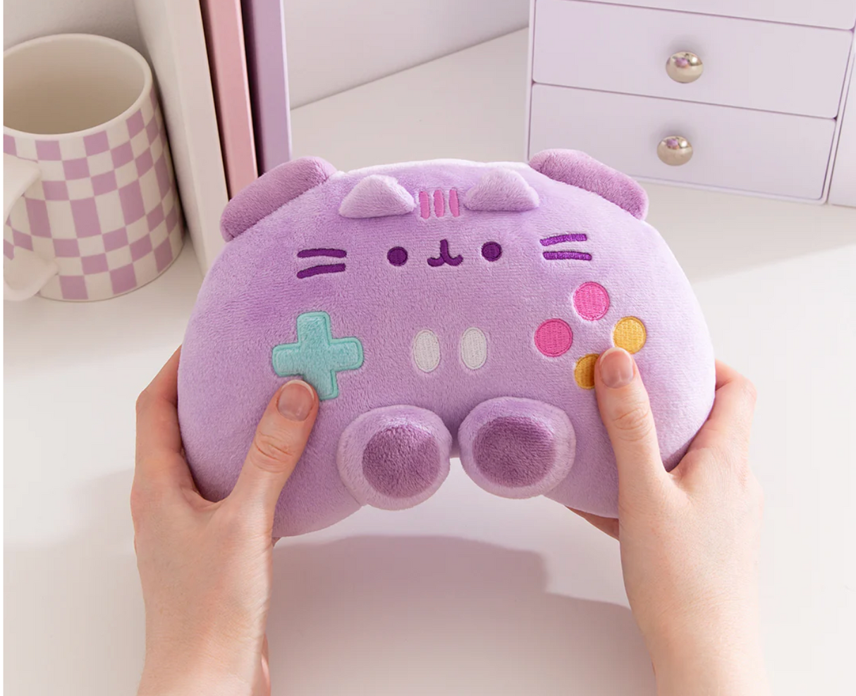 Pusheen Gamer: Controller plush toy in lavender with embroidered details and colorful gaming buttons held in hands.