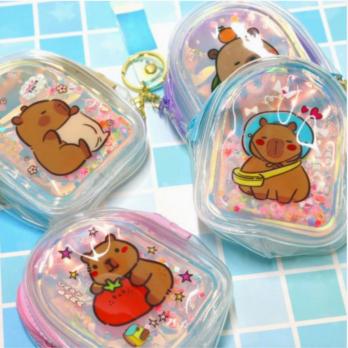 Set of four holographic capybara mini pouches with glitter and gold keyrings for small accessories and coins.
