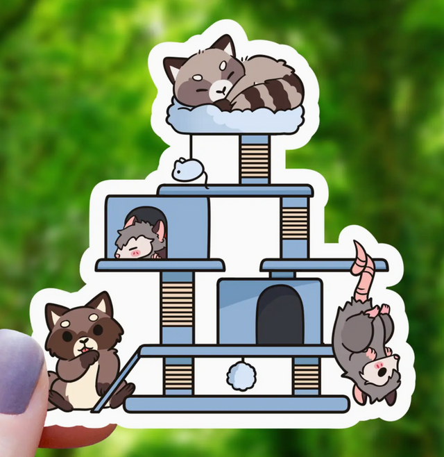 Cute sticker showing a raccoon and opossum playing and resting on a multi-level cat tree structure