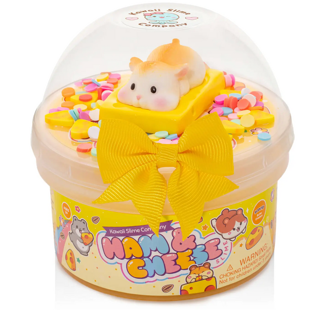 Clear container of glossy yellow slime with colorful sprinkles, a cute hamster on cheese charm, and a yellow bow on the lid