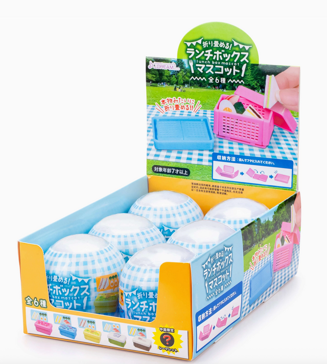 Display box with six blue and white checkered foldable lunch box capsules, each hiding a surprise collectible figure inside