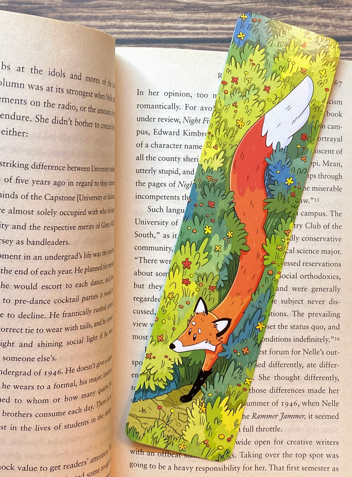 Colorful bookmark featuring a red fox walking through tall wild grasses with flowers on a wood surface background