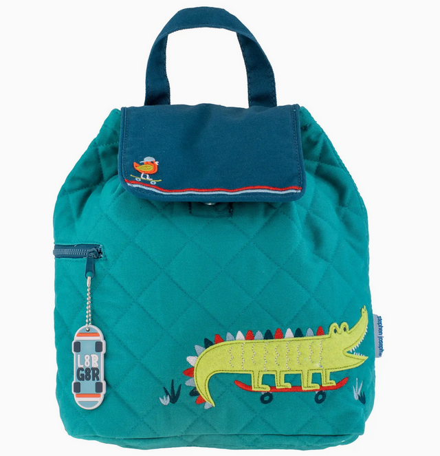 Teal quilted backpack with embroidered alligator on skateboard and bird detail on flap closure