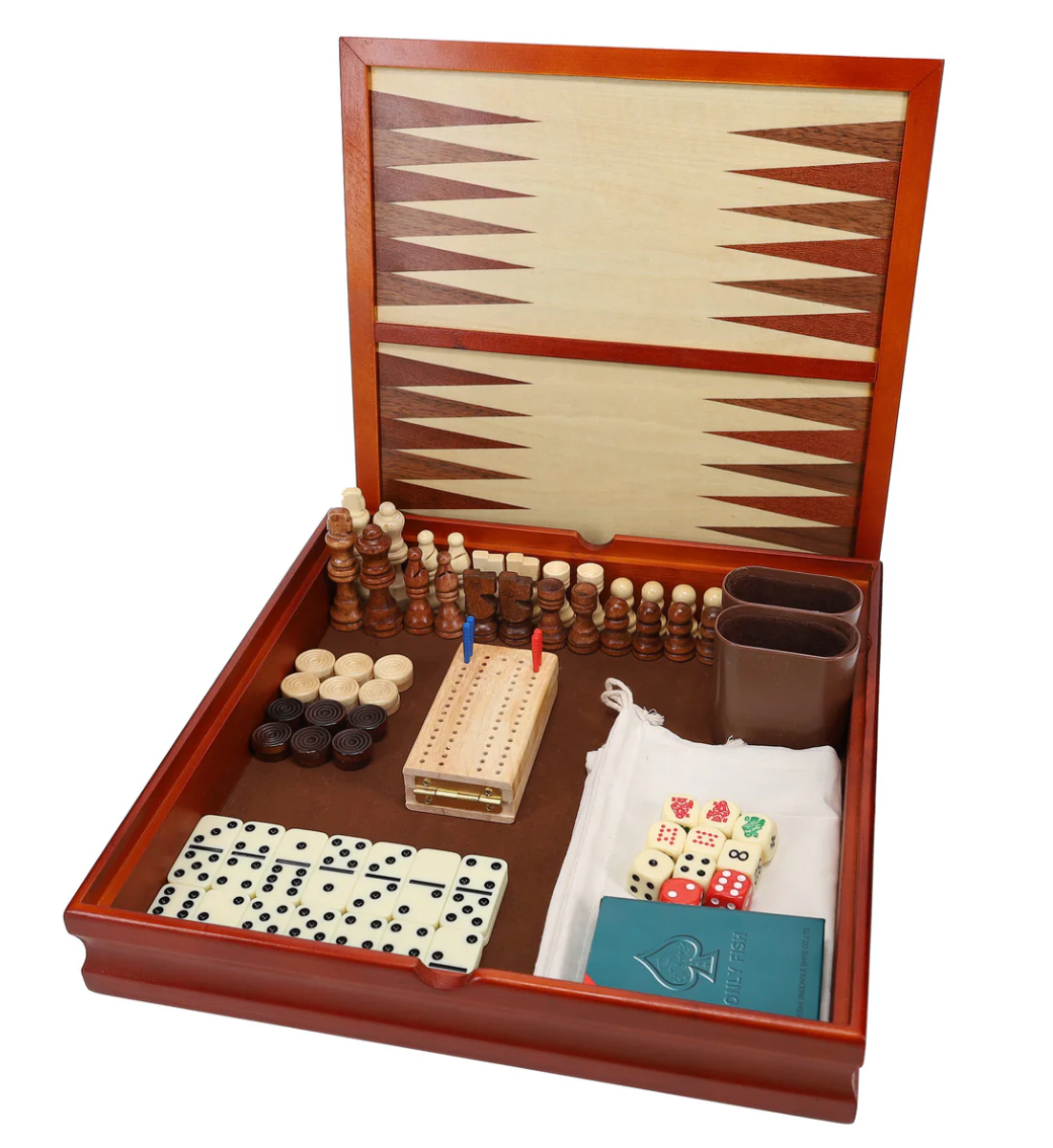 Open wooden game set displaying backgammon board, chess pieces, checkers, dominoes, cribbage board, dice, and card deck inside