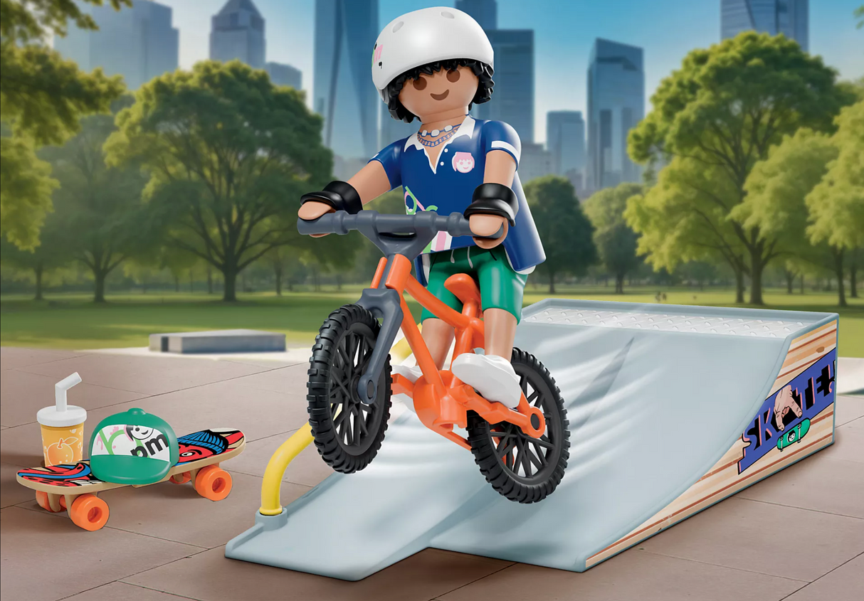 Figure riding orange bike on ramp with skateboard, helmet, drink, and park background