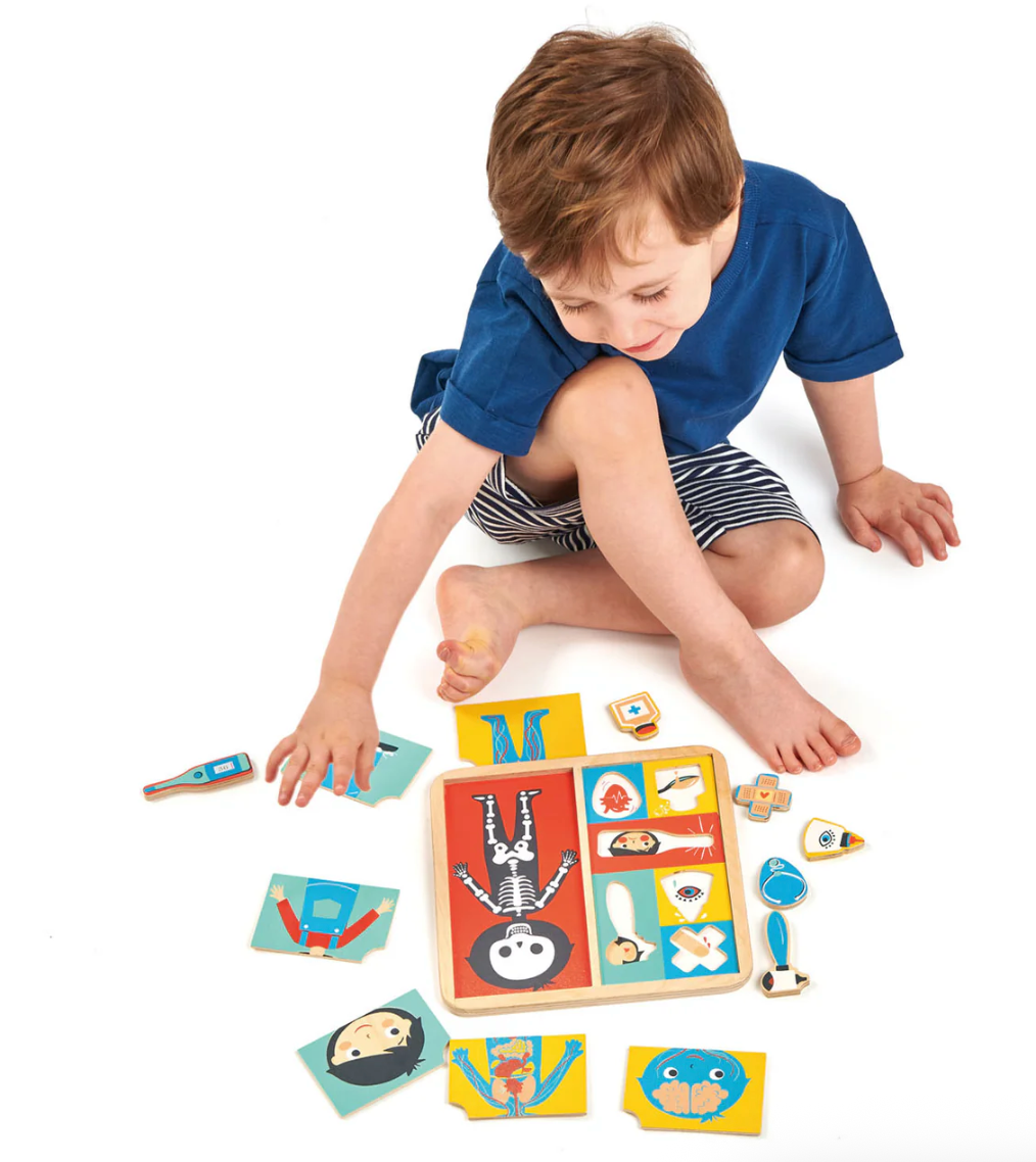 Young child playing with colorful educational puzzle teaching how the body works and heals with 12 pieces