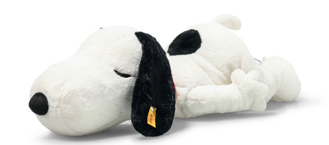 Large plush Snoopy lying on tummy with closed eyes and relaxed smile, ears softly hanging down.