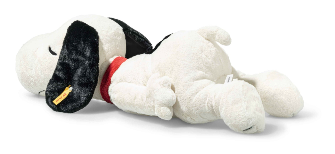 Large plush Snoopy lying on his tummy with eyes closed and a gentle smile, ears relaxed and floppy.
