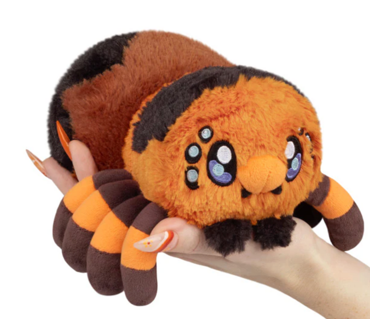 Soft plush tarantula toy with bright orange and brown colors held in a hand, designed for all ages.