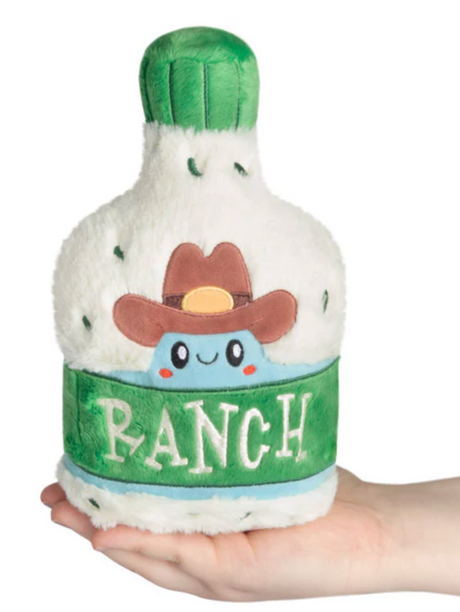 Hand holding a cute plush bottle of ranch dressing with a cowboy hat and green label reading ranch