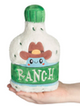 Hand holding a cute plush bottle of ranch dressing with a cowboy hat and green label reading ranch