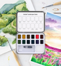 Compact watercolor set with 12 nature-inspired landscape colors, brush, sponge, and paper for painting outdoors