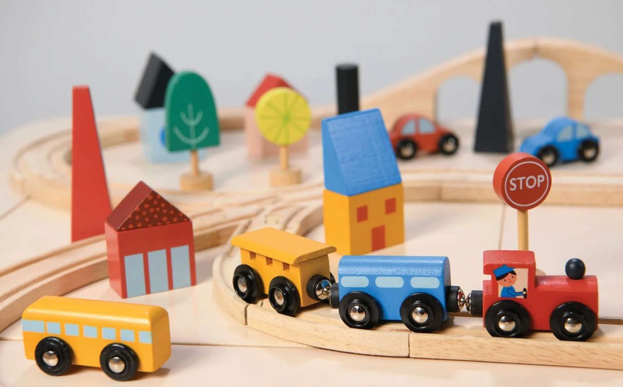 Wooden town train set with colorful train, track, traffic signs, trees, and buildings for imaginative play.