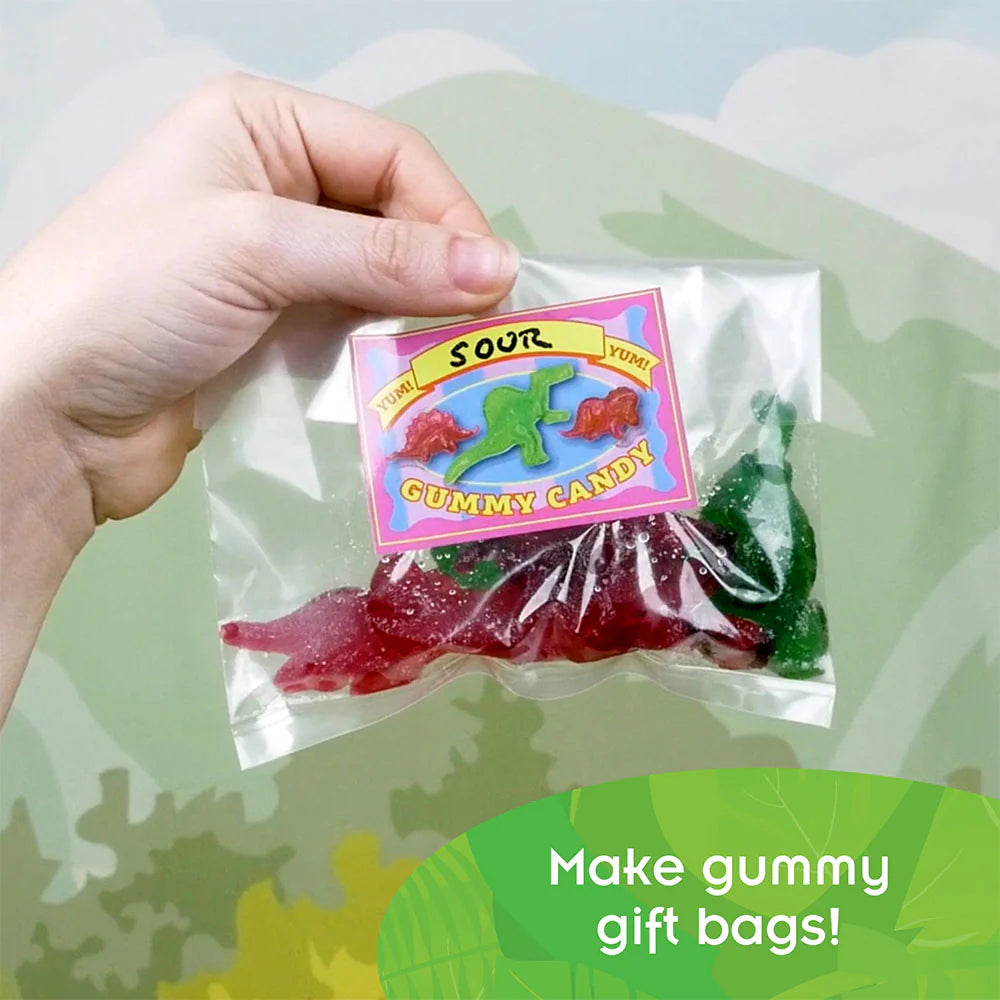 Hand holding a bag of colorful dinosaur-shaped gummies from the Dinosaur Gummy Candy Lab product.