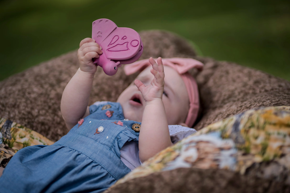 Organic Rubber Teether Rattle | Butterfly held by baby, made from natural rubber, designed for soothing teething gums.