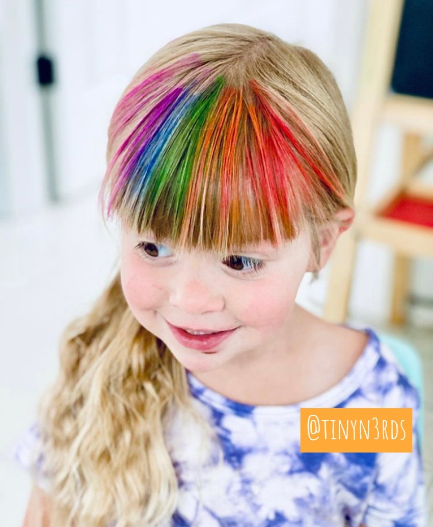 Young child with blonde hair featuring vibrant rainbow colors using Hair Chalk, easy to apply and non-toxic.