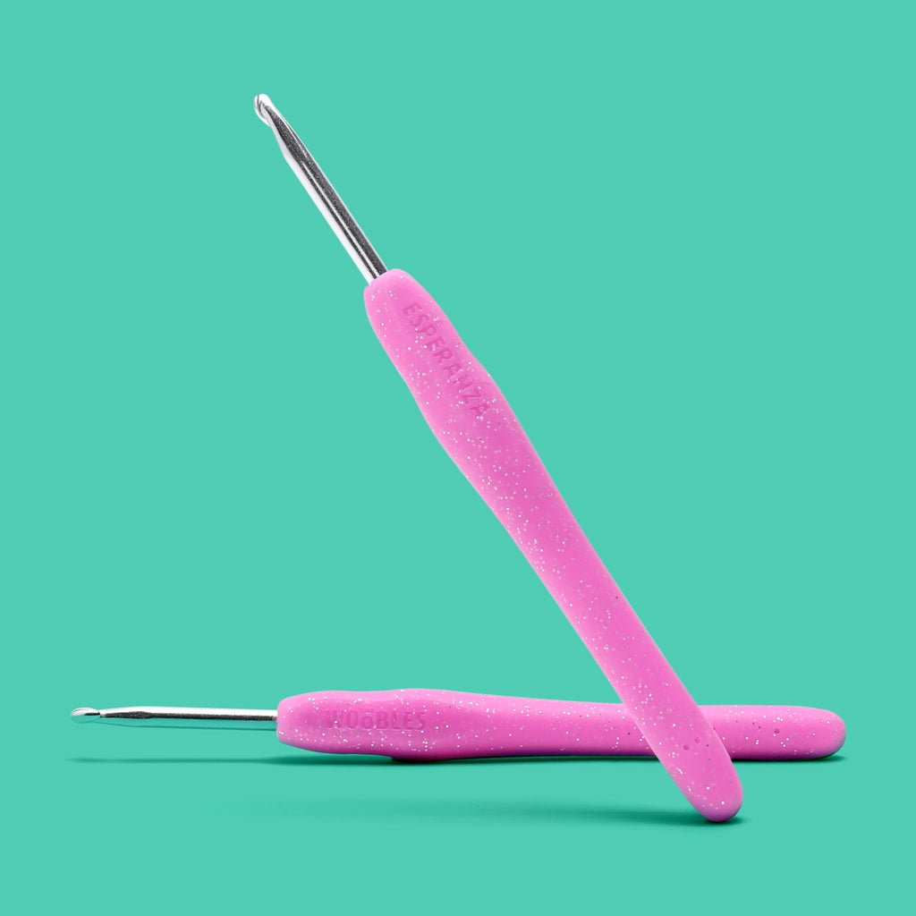 The Woobles Crochet Kit | Esperanza the Fairy pink crochet hooks with ergonomic handles on teal background